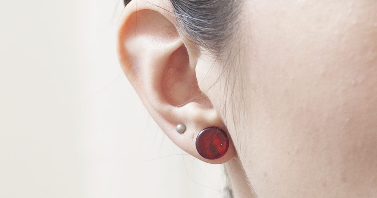 Hoe je doorboorde oorbellen uit je oor kunt verwijderen