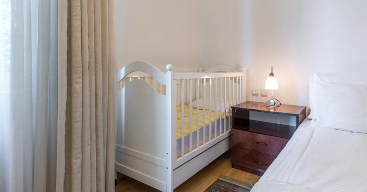 Wie man ein Vorlagenschlafzimmer anordnet, um Krippe u. Baby-Speicher einzuschließen